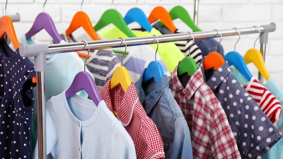 детская одежда на вешалках в магазине